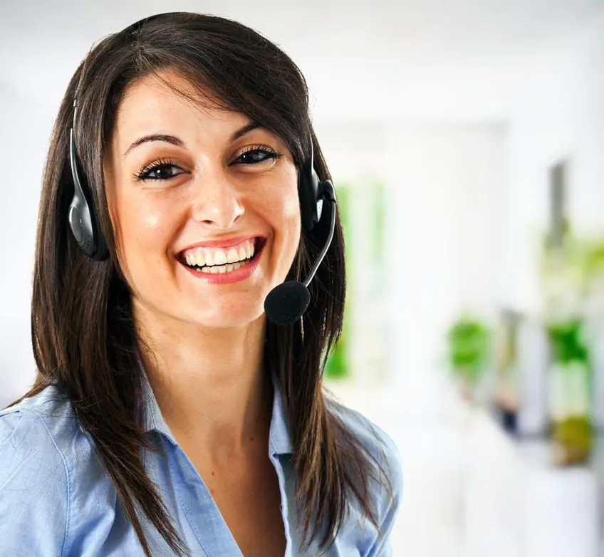 A woman wearing headphones smiling for the camera.