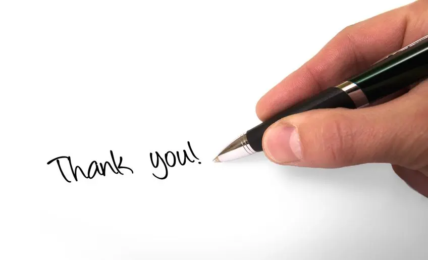 A person writing " thank you ".