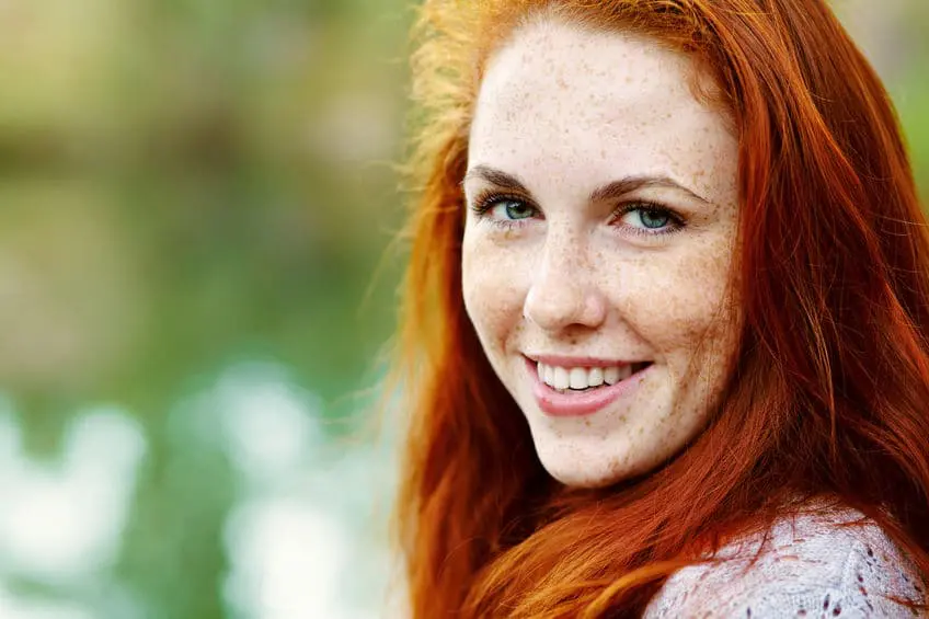 A woman with red hair smiling for the camera.