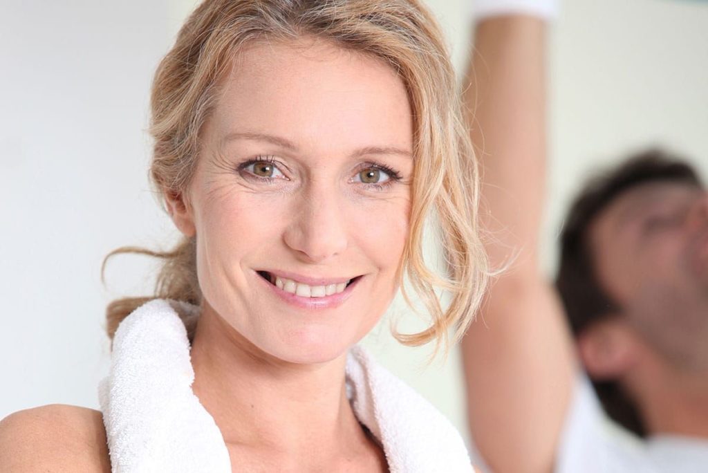 A woman with blonde hair and white shirt smiling.