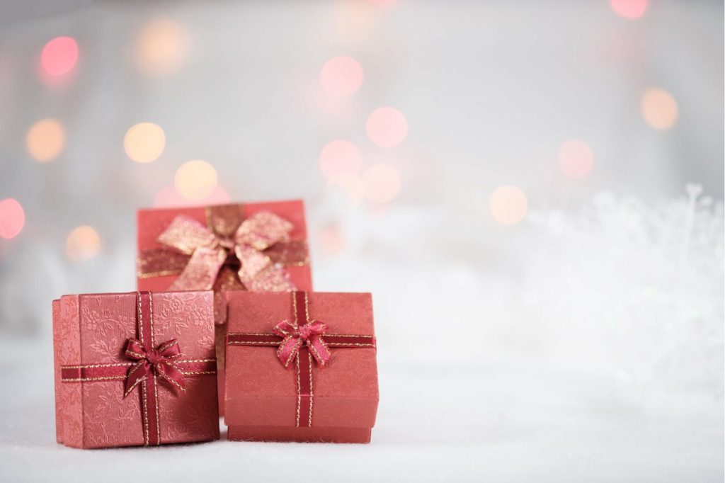 Three red gift boxes with bows on a table.