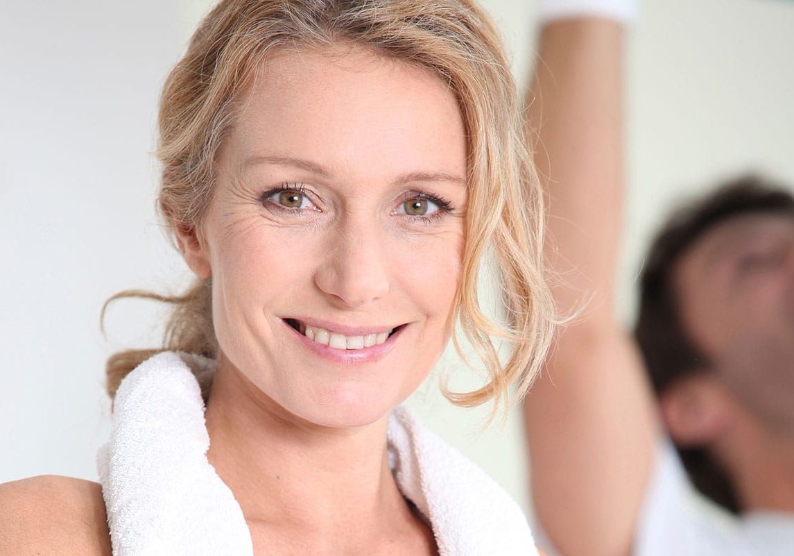 A woman with blonde hair and white shirt smiling.