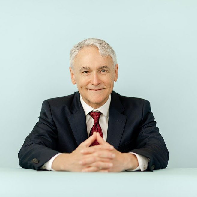 A man in suit and tie sitting at a table.