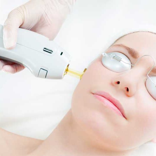 A woman getting her eyes cleaned by an ophthalmologist.