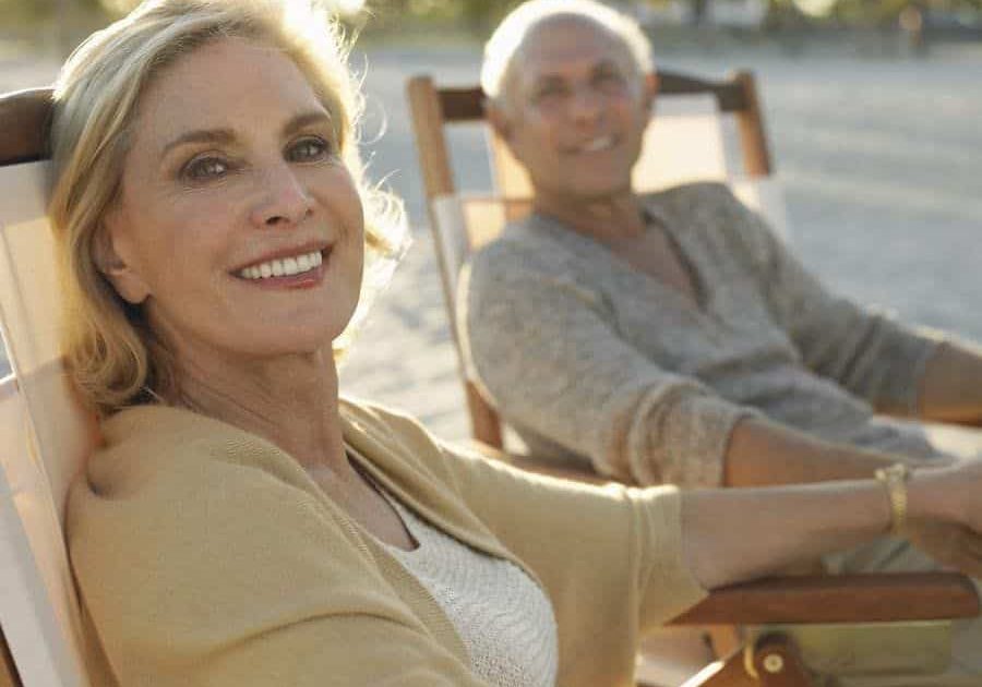 A woman sitting in an outdoor chair next to another person.