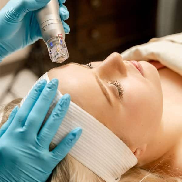 A woman getting her face waxed at the spa.